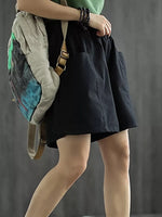 Person wearing a black skirt with a gray backpack against a gray background