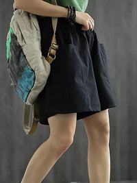 Person wearing a black skirt with a gray backpack against a gray background