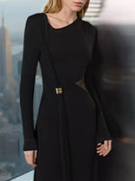 Woman wearing a black dress with cut-out design in an urban setting