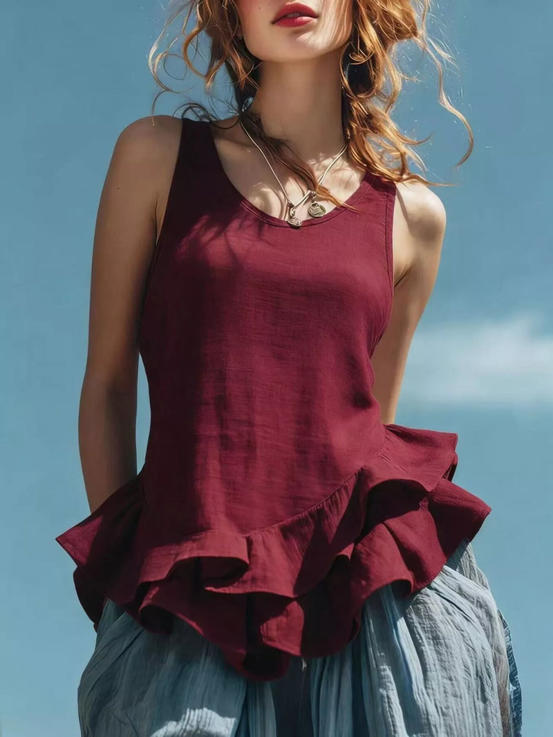 Woman wearing a burgundy ruffled top against a blue sky