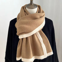 Brown and beige scarf on a mannequin with a plain background