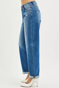 Left side view of Blue jeans worn by a person on a white background