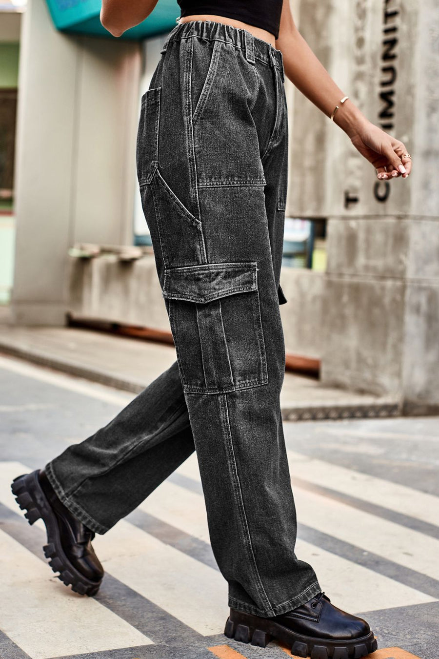 Person wearing black cargo pants walking on a zebra crossing with a blurred background