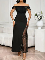 Woman wearing a black off-shoulder dress with sheer panels in a room.