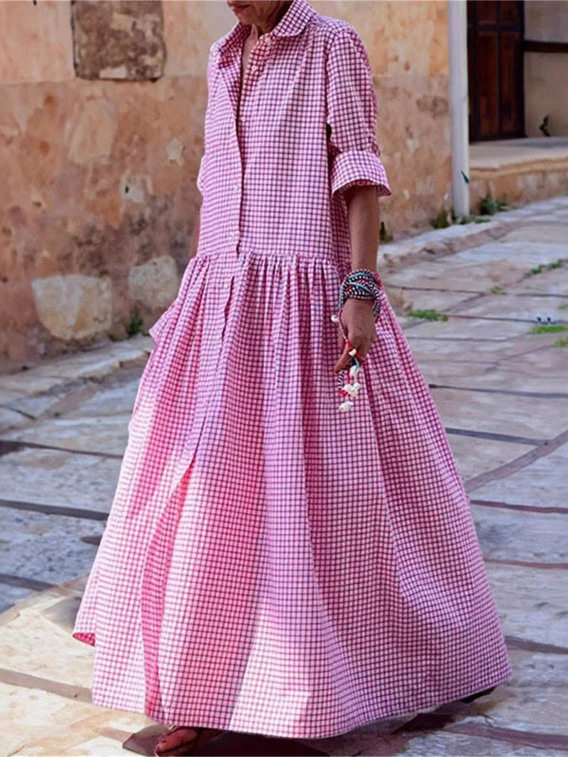 Person wearing a pink checkered dress on a stone pavement.