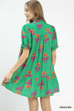 Green dress with floral pattern worn by a model on a white background