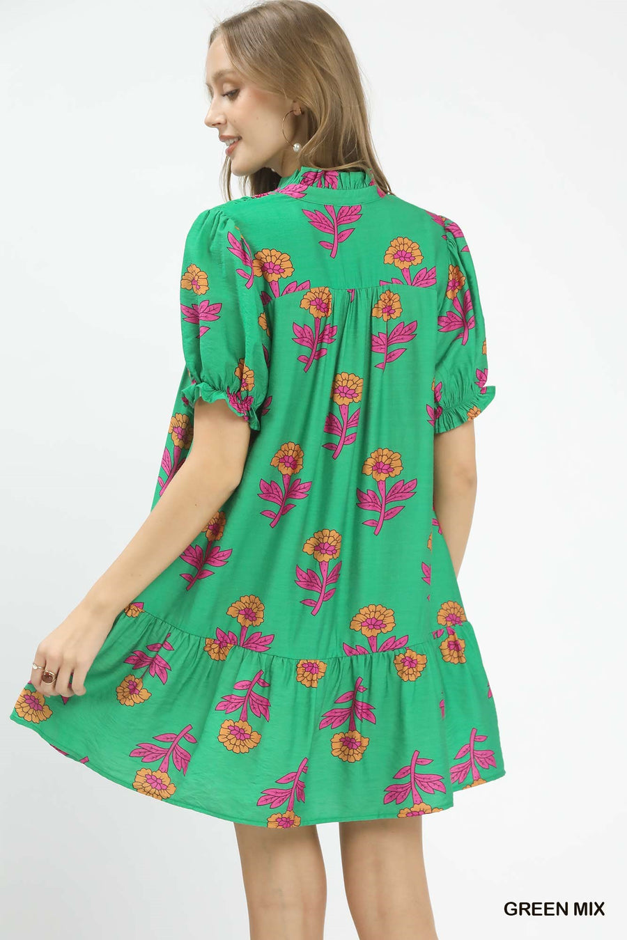 Green dress with floral pattern worn by a model on a white background