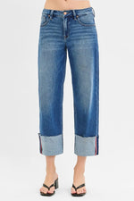 Blue jeans with rolled-up cuffs on a white background