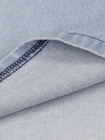 Close-up of blue denim fabric with a visible seam.