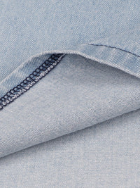Close-up of blue denim fabric with a visible seam.
