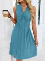 Woman wearing a blue dress holding a coffee cup indoors.