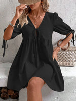 Woman wearing a black dress with a textured wall background
