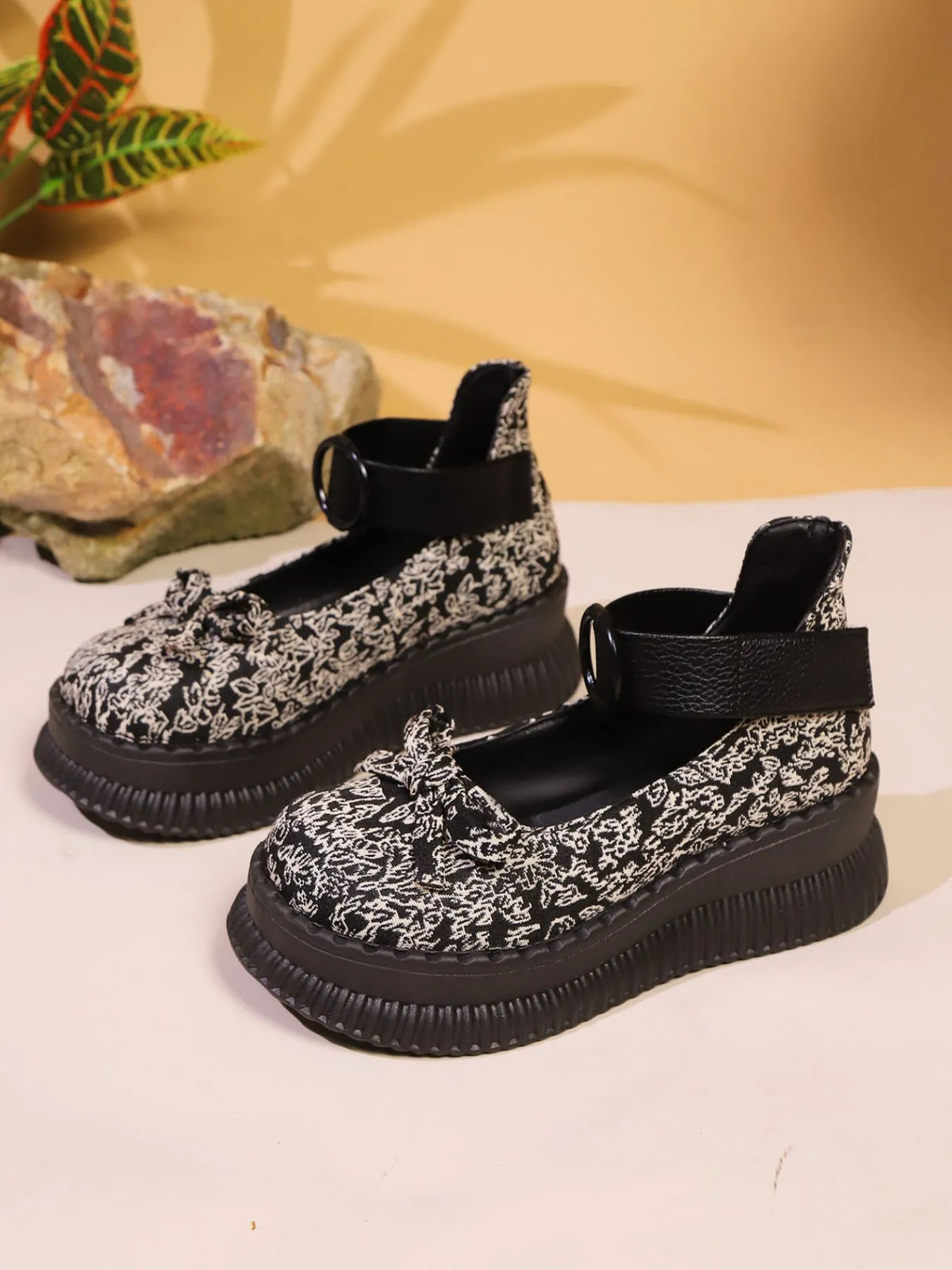 Black and white floral patterned shoes on a light background