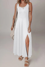 Woman wearing a white sleeveless dress with a slit on a plain background