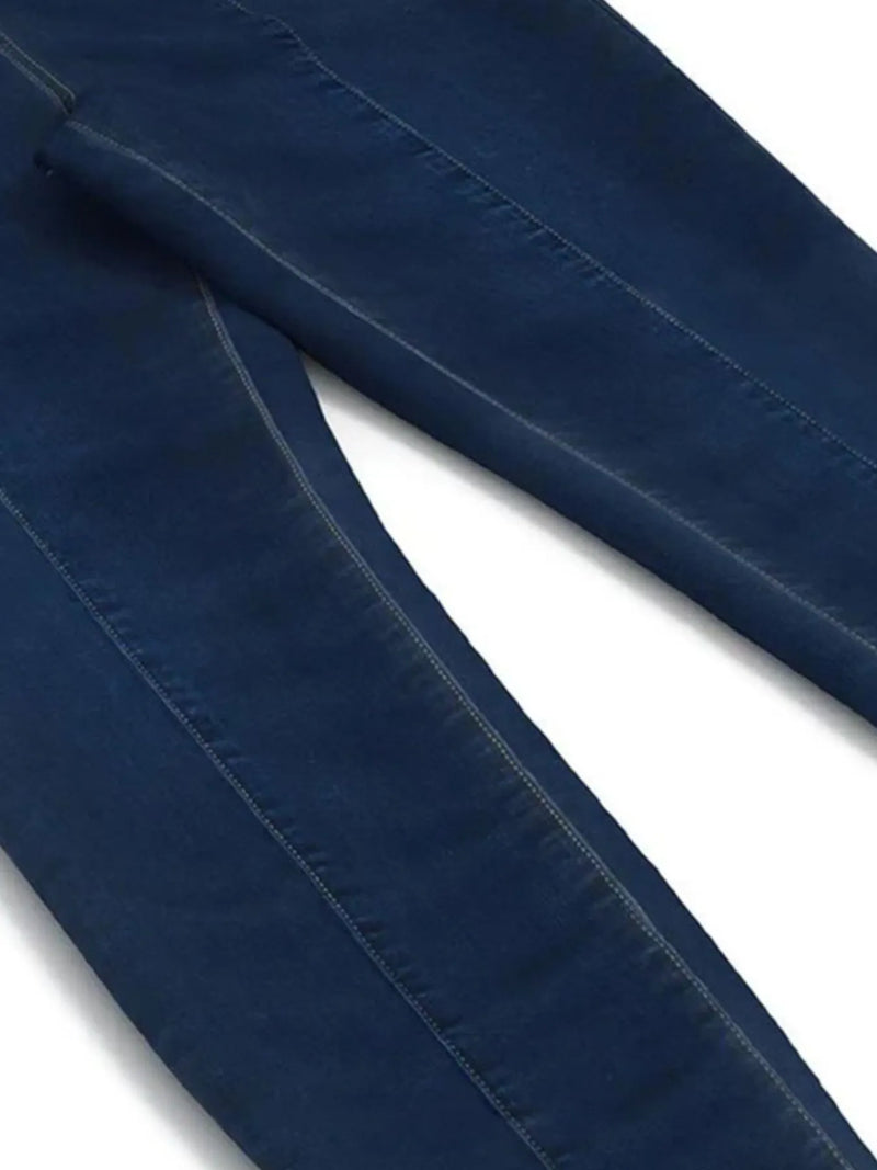 Close-up of blue denim fabric with visible stitching on a white background