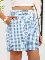 Blue and white checkered shorts worn by a person with a blurred background