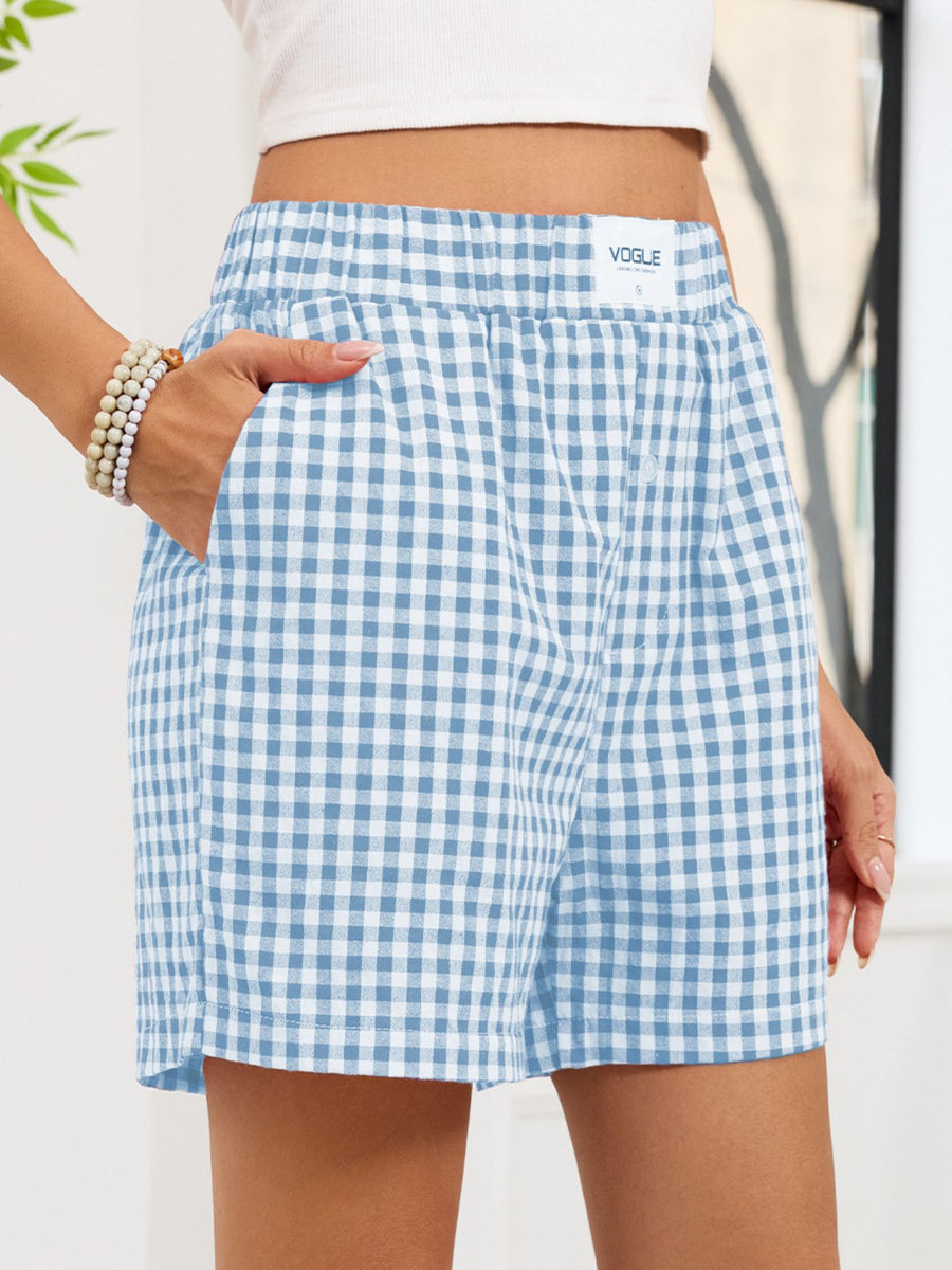 Blue and white checkered shorts worn by a person with a blurred background