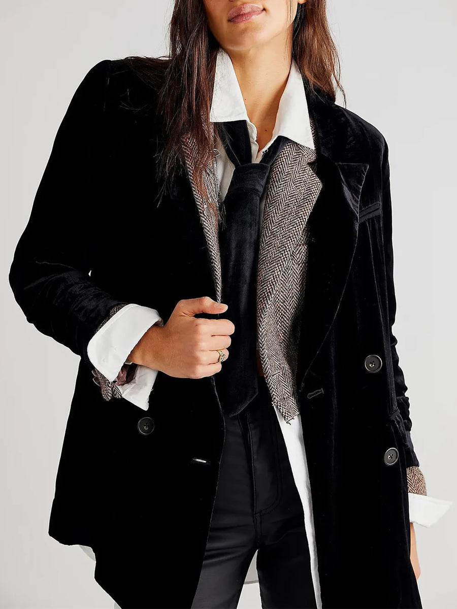 Person wearing a black coat with a white shirt and patterned scarf on a light gray background