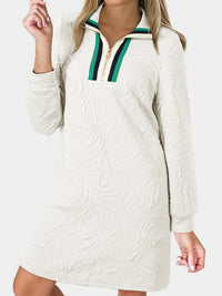 White textured dress with green and black zipper detail on a white background