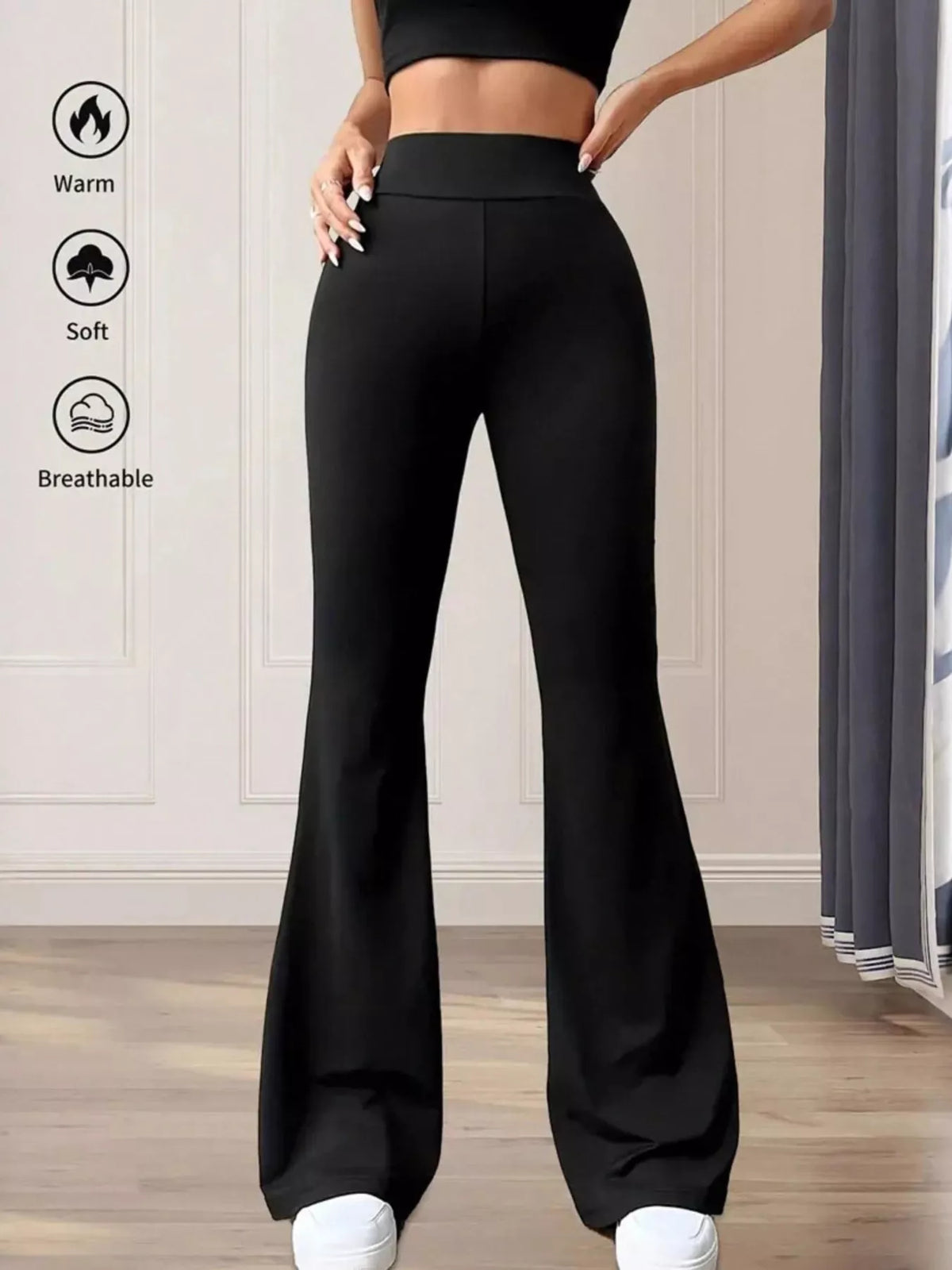 Black flared pants worn by a person with features indicating warmth, softness, and breathability on a neutral background.