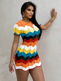 Woman wearing a colorful zigzag pattern dress against a plain background