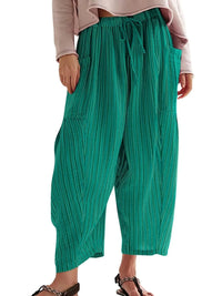Green wide-leg pants worn by a person on a white background