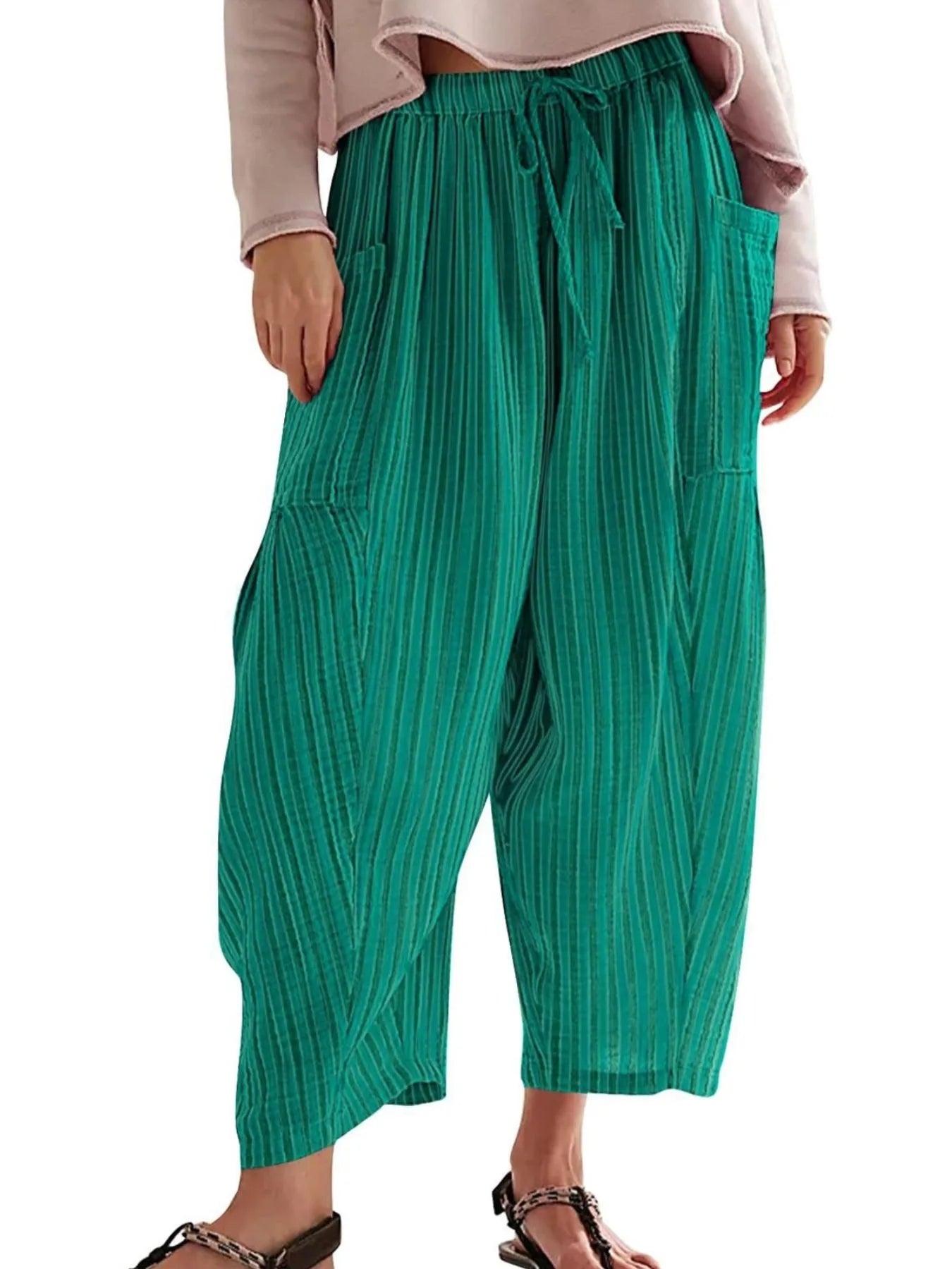 Green wide-leg pants worn by a person on a white background
