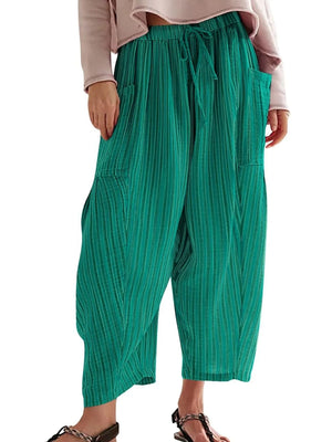 Green wide-leg pants worn by a person on a white background
