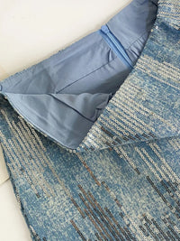 Close-up of a blue fabric with a textured pattern on a white background