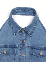Close-up of a blue denim jacket with collar and buttons on a white background