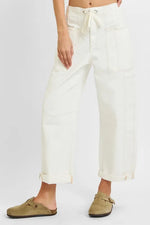 Person wearing white pants with a drawstring waist on a plain background