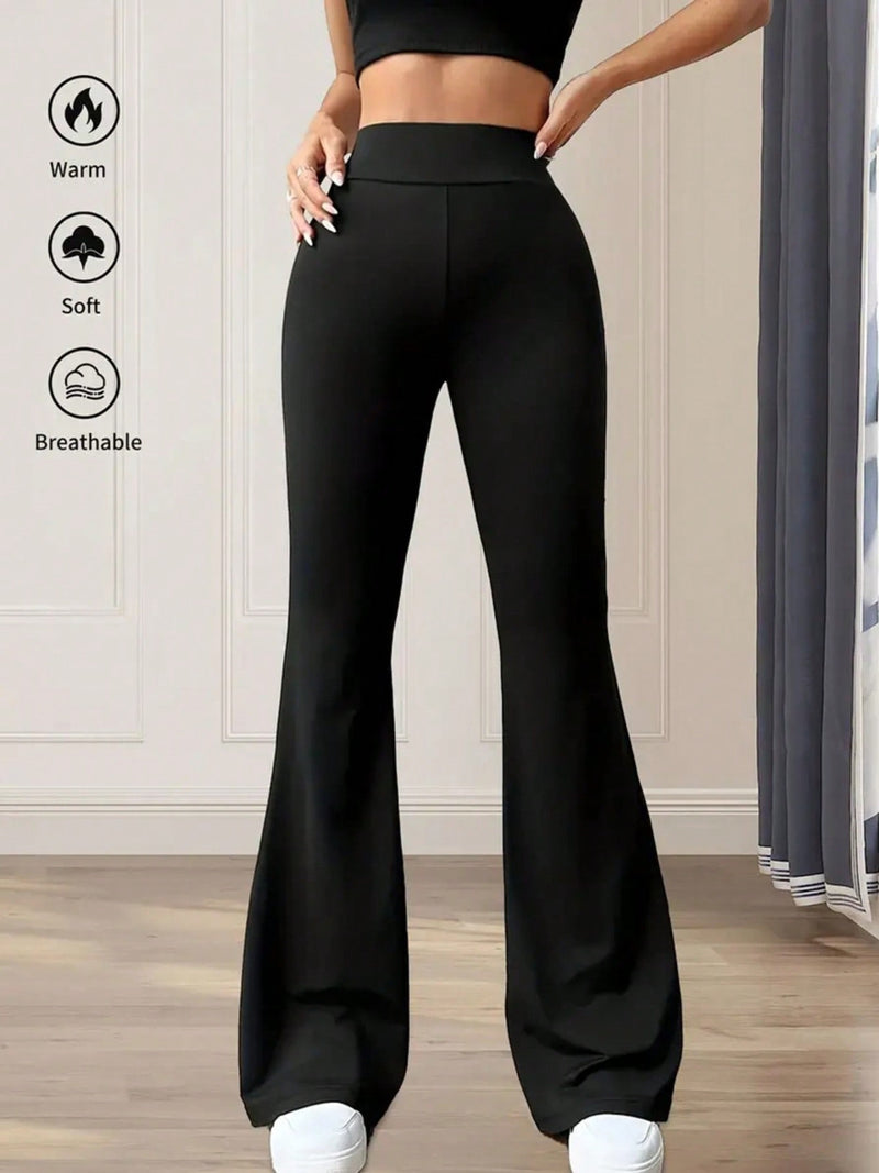 Black flared pants being worn with text icons indicating warmth, softness, and breathability.