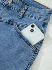 Smartphone in a blue denim pocket on a light background