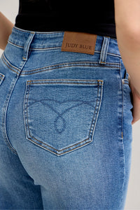 Close-up of blue jeans with a Judy Blue belt and black top.