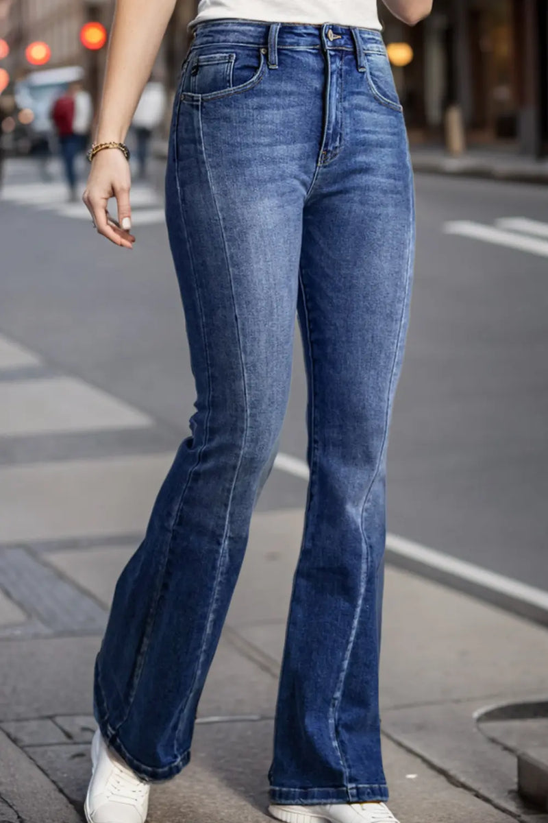 Person wearing blue flared jeans on a city street.