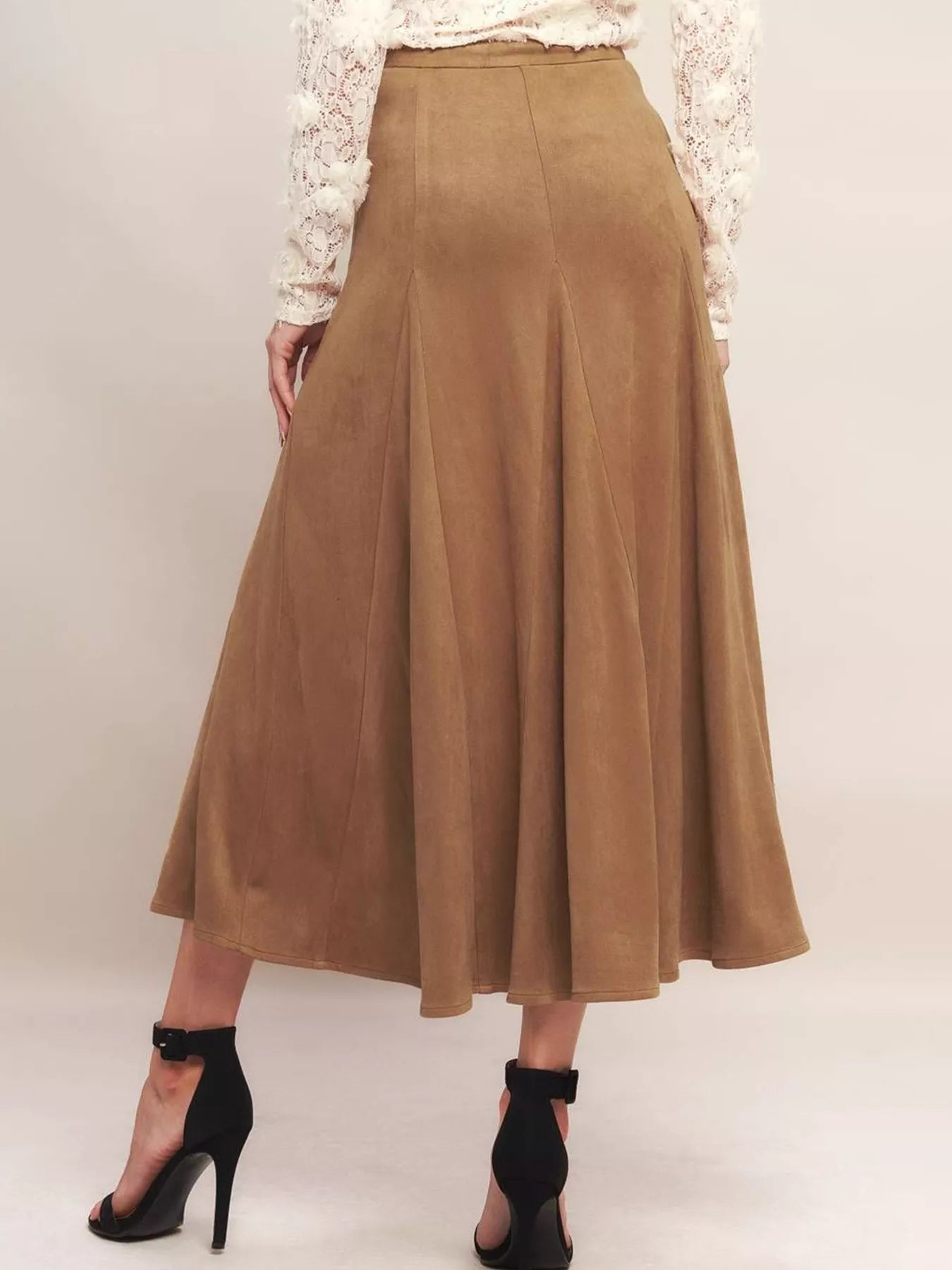 Brown suede skirt worn by a person on a white background