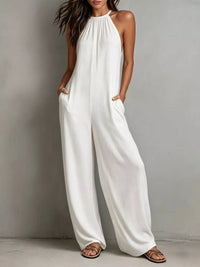 Woman wearing a white jumpsuit against a plain background