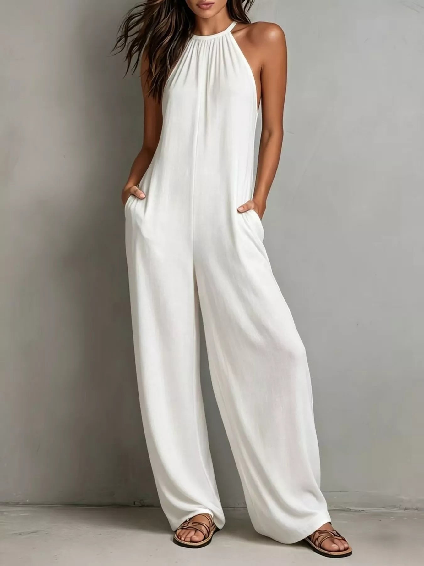 Woman wearing a white jumpsuit against a plain background