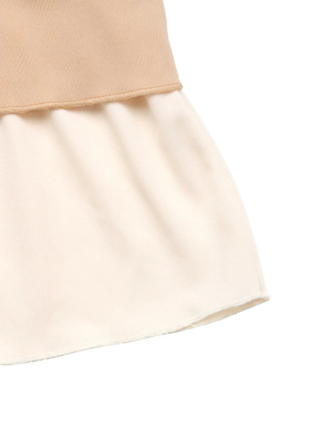 Close-up of a beige skirt with a white background