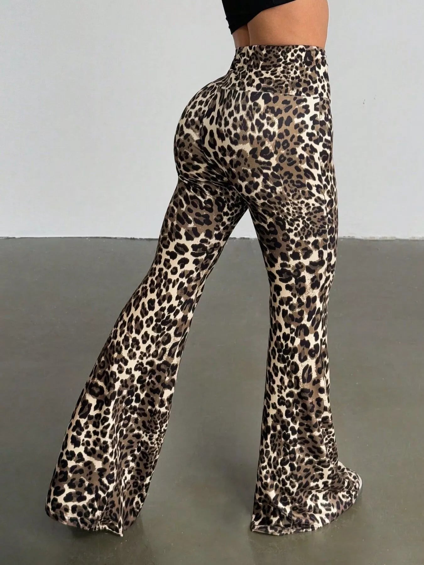 Leopard print flared pants on a plain background