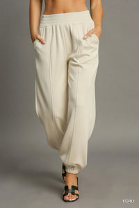 Beige wide-leg pants worn by a person on a gray background