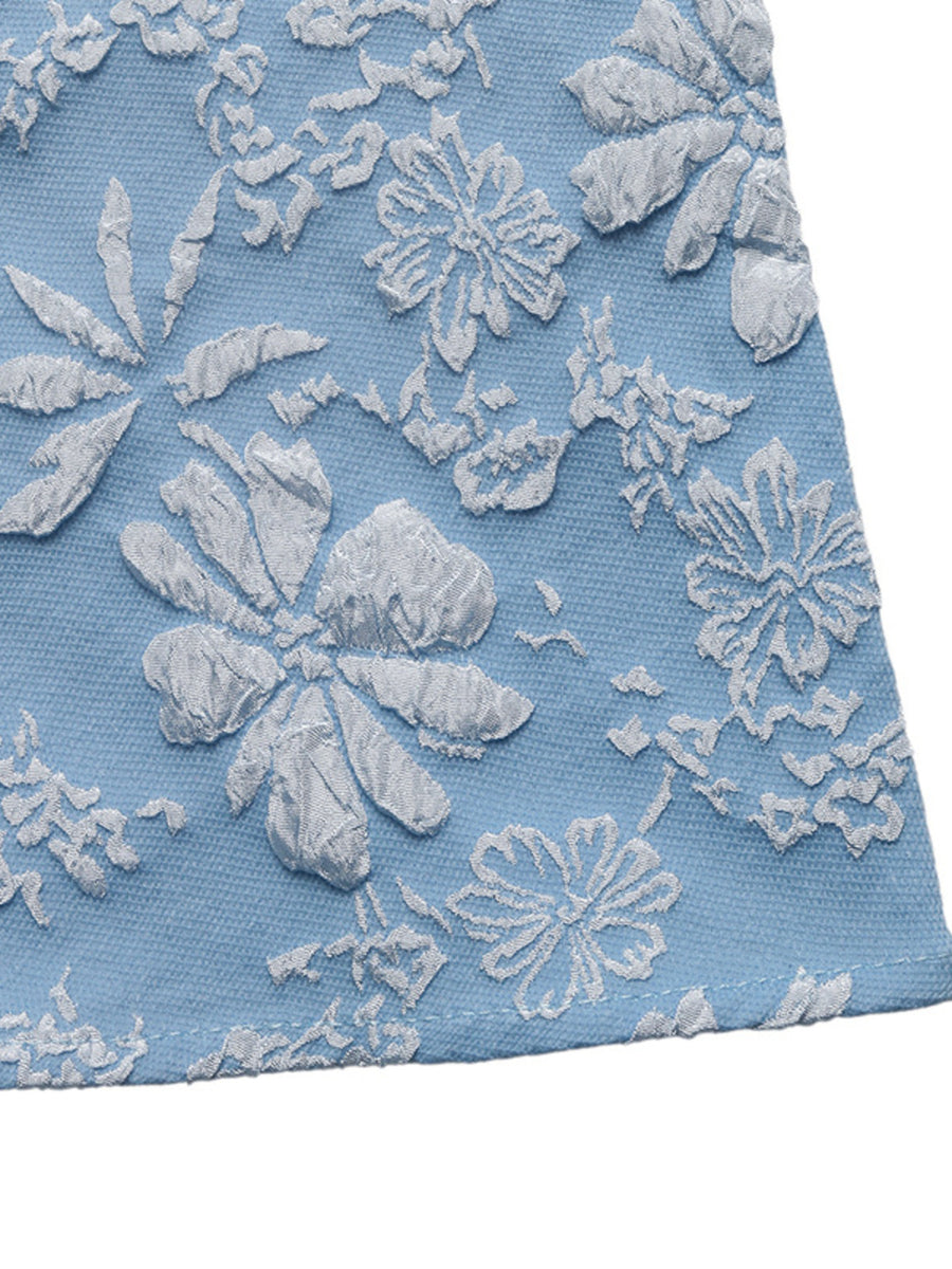 Close-up of blue fabric with white floral lace embroidery