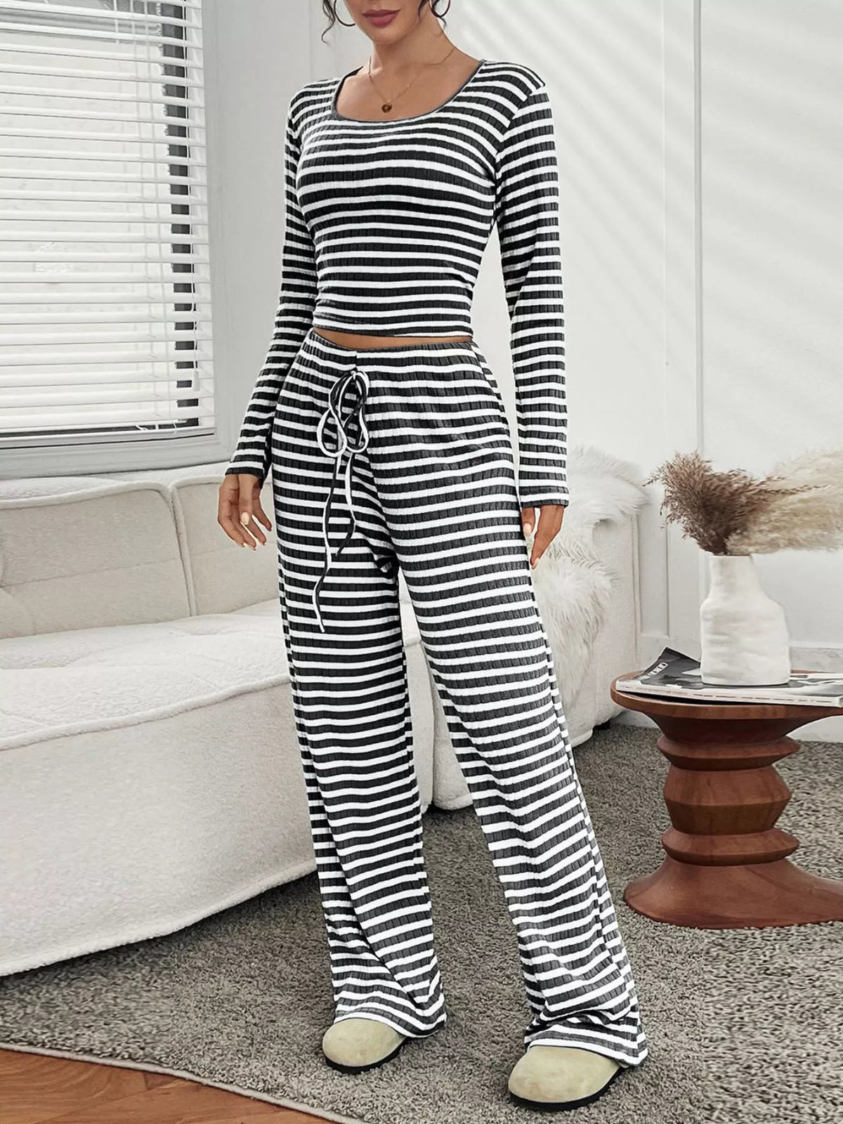 Person wearing a black and white striped pajama set in a living room.