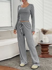 Person wearing a black and white striped pajama set in a living room.