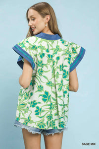 Woman wearing a green floral kimono-style garment against a light blue background
