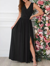 Woman wearing a black sleeveless dress with a slit, standing next to a floral arrangement.