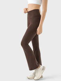 Brown flared pants worn by a person on a white background