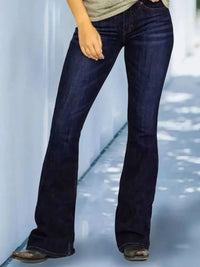 Person wearing dark blue jeans on a light background