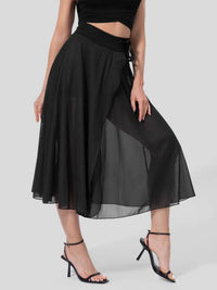 Black skirt worn by a person on a white background