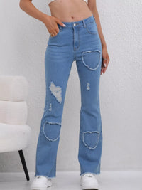 Blue jeans with patchwork design worn by a person on a white background